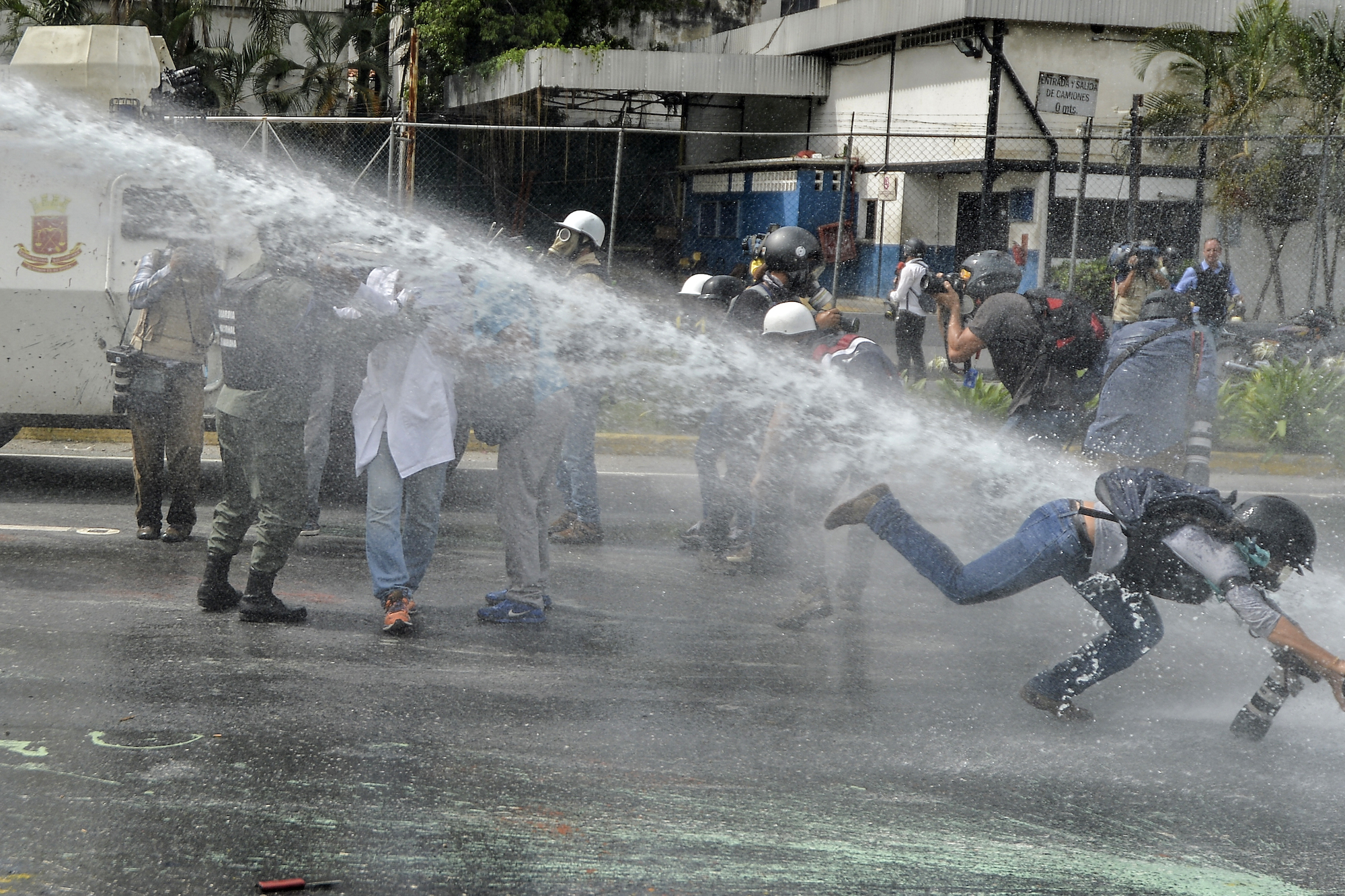 La photographe de AP Ariana Cubillos est attaquée par un canon à eau pendant une manifestation à Caracas, le 22 mai 2017. LUIS ROBAYO / AFP